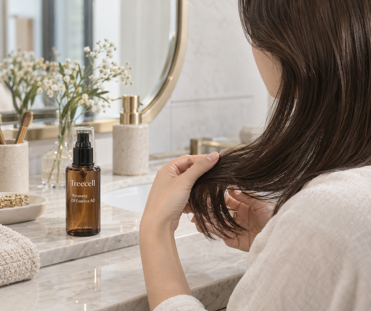 Person applying Treecell Recovery Oil Essence AD to the mid-lengths of clean hair